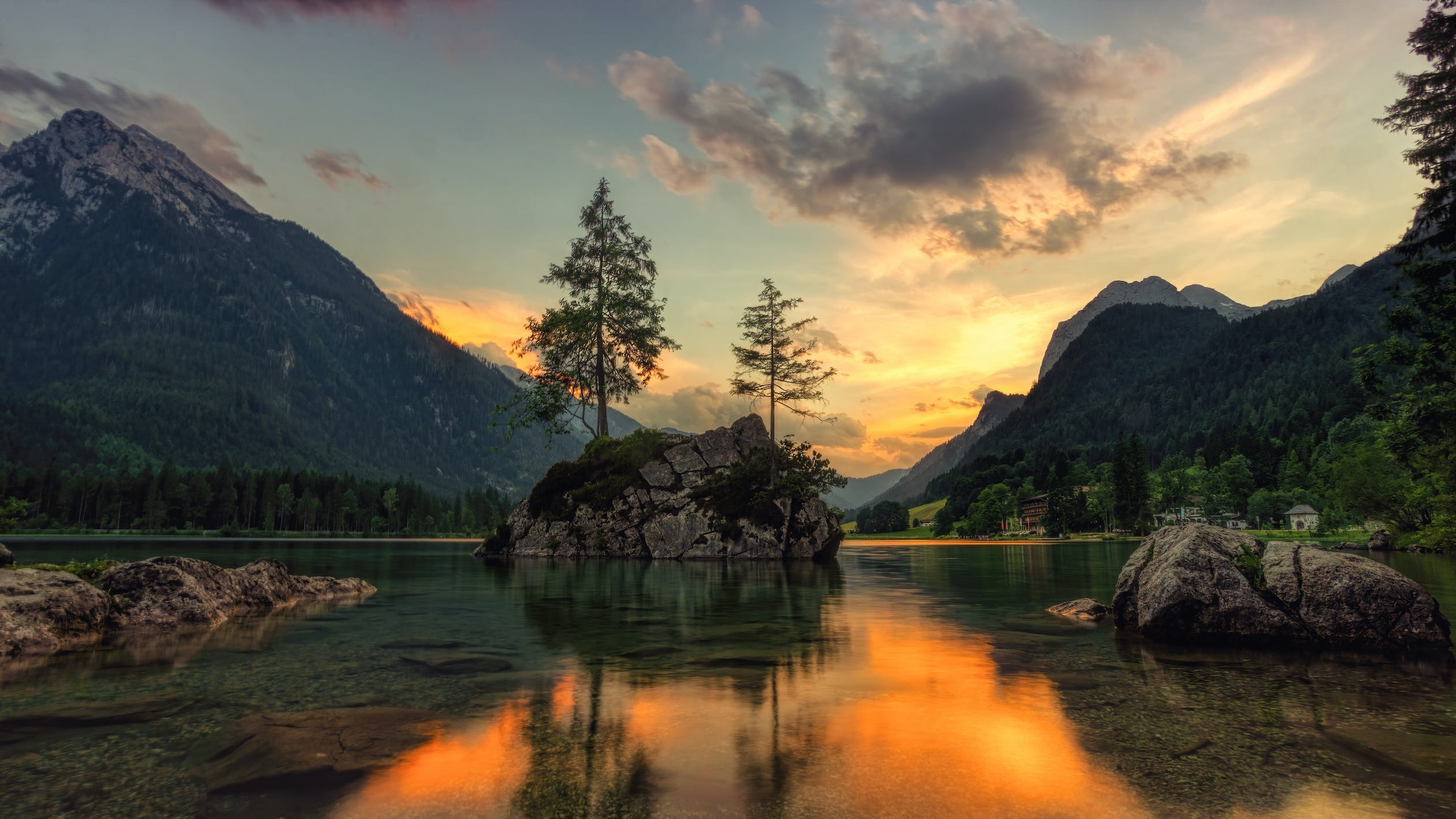 Lake surrounded by mountains at sunrise