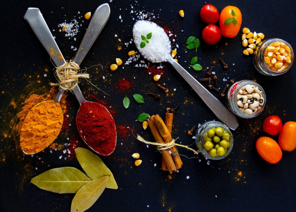 Collection of bright spices and fresh vegetables on table